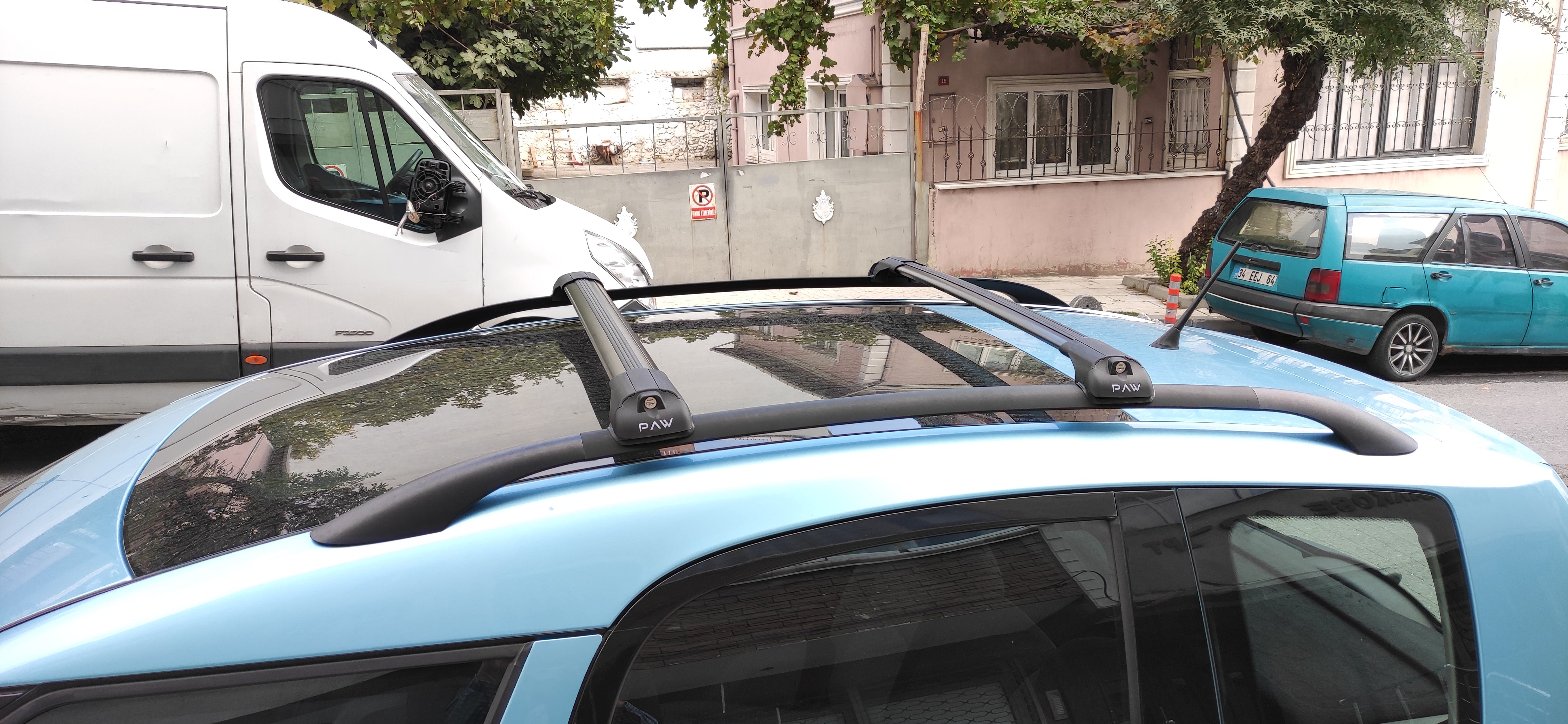 Car with roof rack on a street with buildings and trees in the background Car with roof rack on a street with buildings and trees in the background